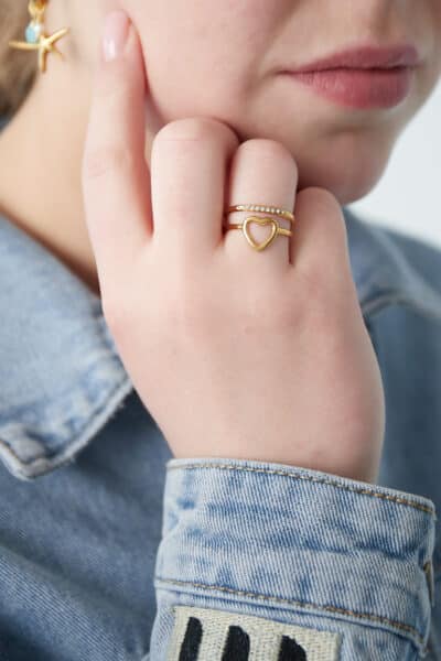 Złoty pierścionek z sercem na dłoni