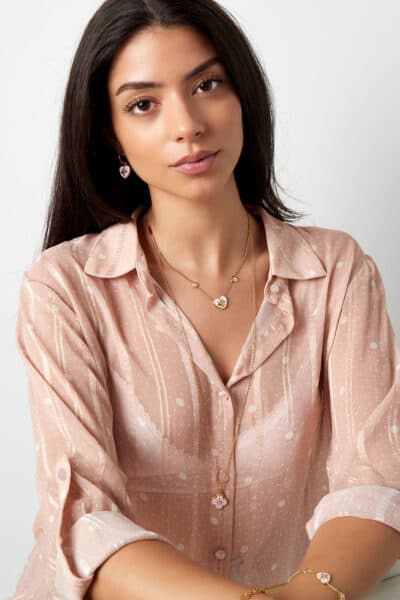 Kobieta w eleganckiej bluzce z biżuterią