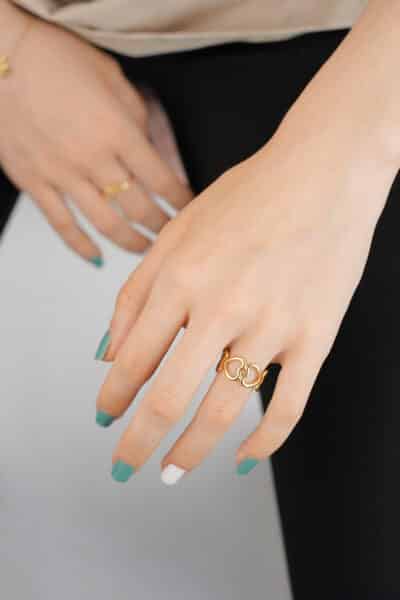 Dłoń z pierścionkiem i zielonymi paznokciami